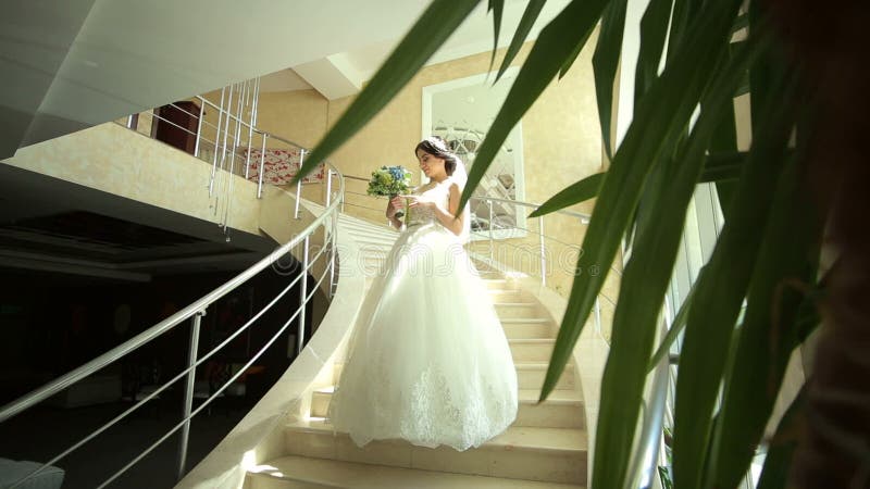 鞋带礼服的一个美丽的新娘在大步站立